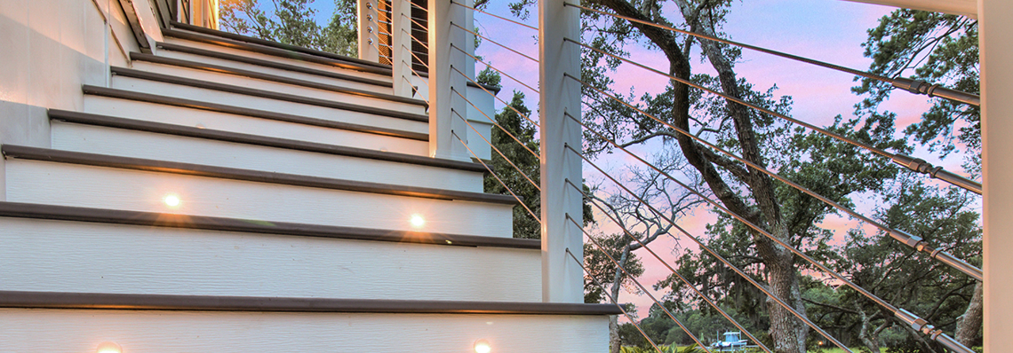 Outdoor staircase with built-in step lights at sunset.